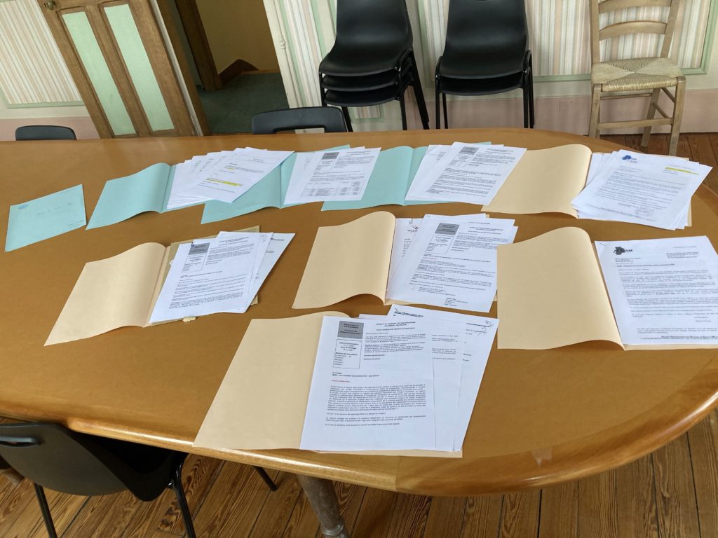 Les documents accompagnant les sujets inscrits à l'ordre du jour d'une réunion du Conseil municipal sont posés sur une table.