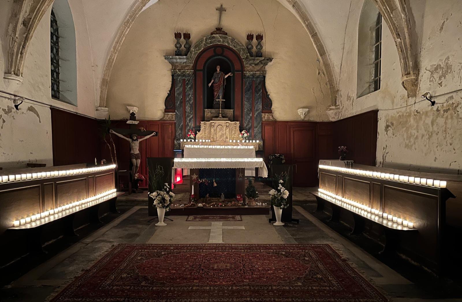 Photos des paroissiens chantant dans et au dehors de l'église. Couronnes de Noël. bougies offertes par des habitants du village de toutes les confessions.